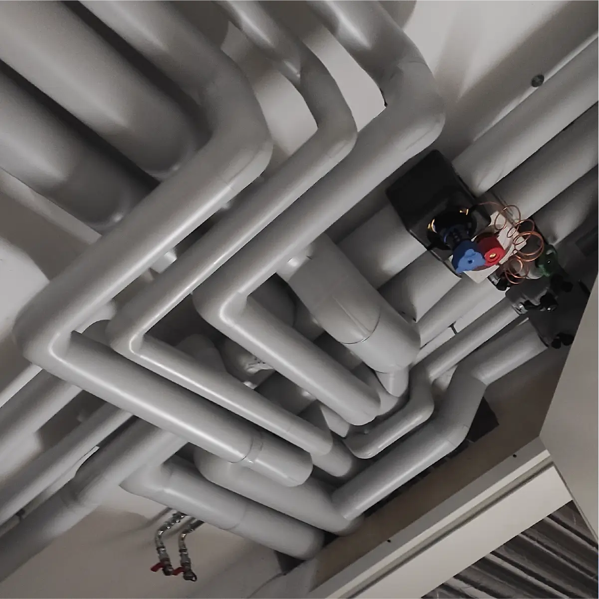 Insulated heating pipework under a ceiling